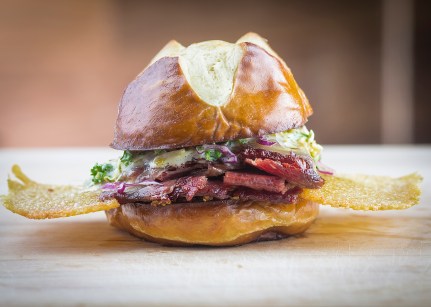 Corned Beef Sandwich -- Slagel Family Farm corned beef, grain mustard, piled on ribbon of crispy-seared artisan Swiss cheese, topped with home-made cole slaw, Thousand and One Island dressing, sandwiched on pretzel roll made exclusively for Doc B's by 75-year-old Bennison's Bakery in Evanston. 